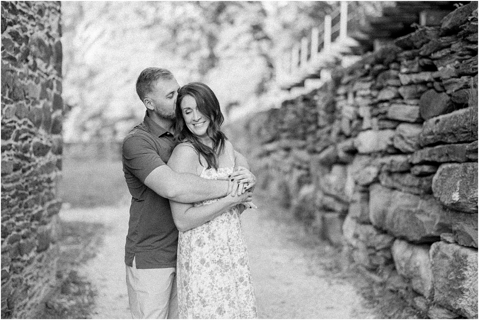 black and white image of mom and dad embracing for family photos in historic harpers ferry wv