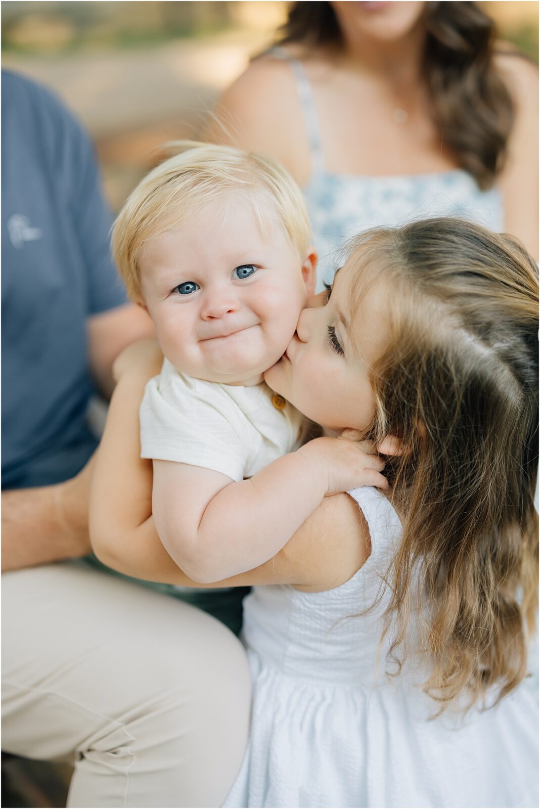 big sister kisses little brothers cheeks in family photos in harpers ferry west virginia