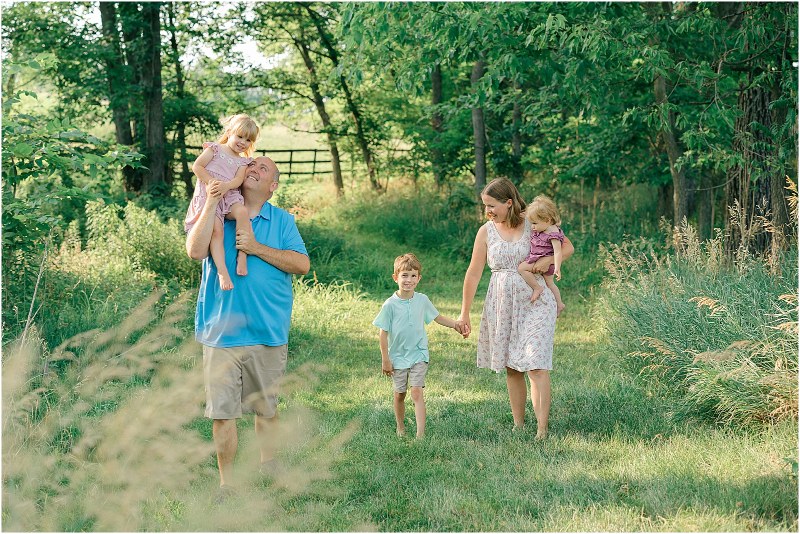 family of five holding hands walking together at their family session in frederick, maryland.