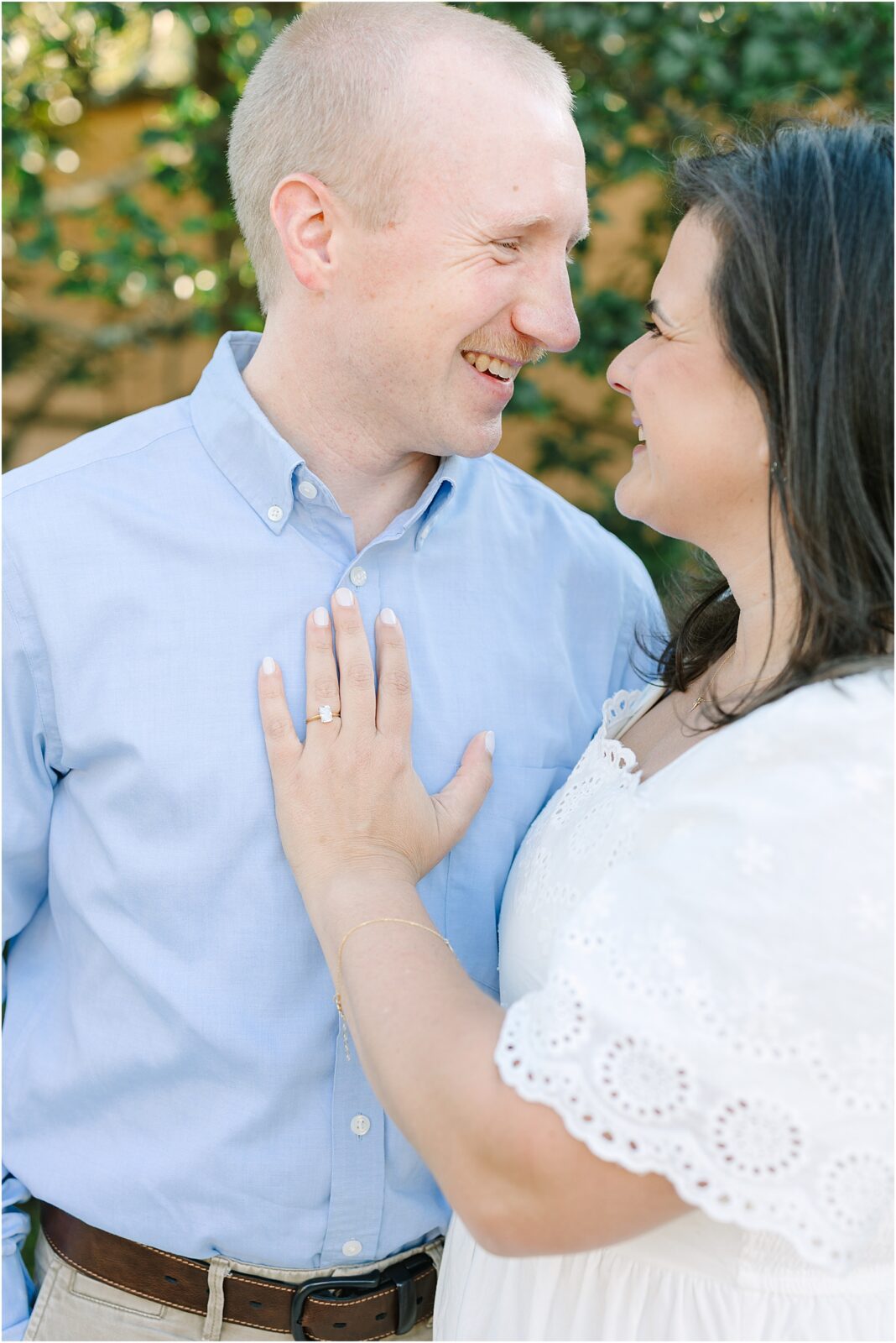 Bride to be with her hand on fiance's chest.