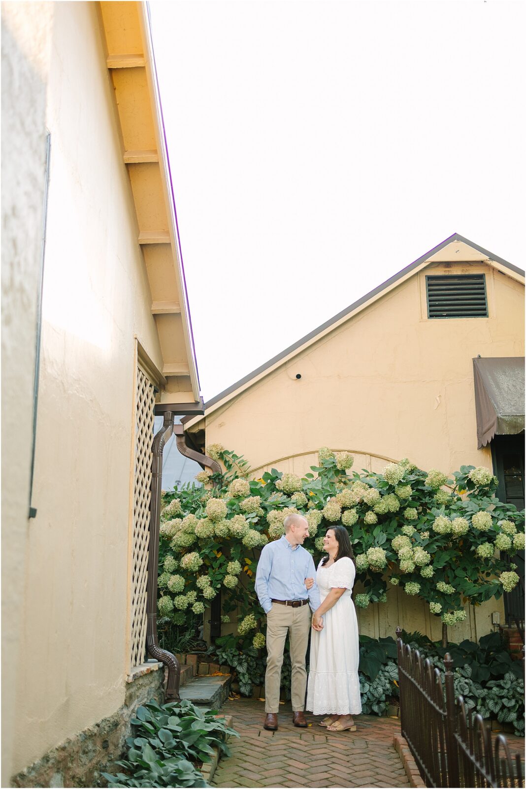 engaged couple walking down stone pathway at red fox inn in middleburg, virginia.